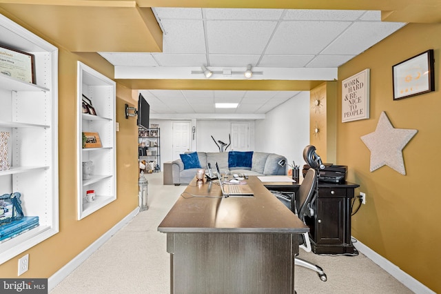 carpeted home office featuring a paneled ceiling