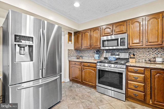 kitchen with backsplash, light stone countertops, stainless steel appliances, and a textured ceiling