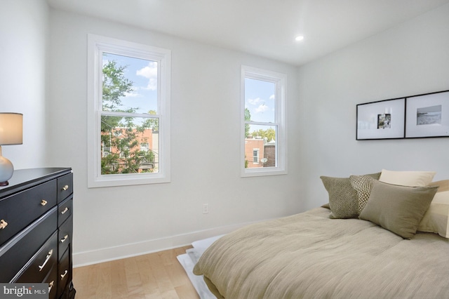 bedroom featuring multiple windows and light hardwood / wood-style floors