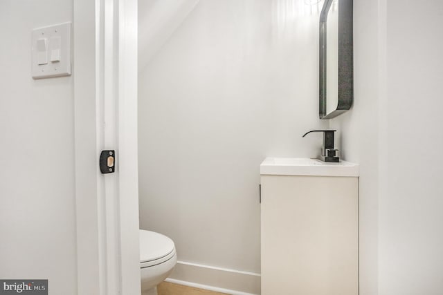 bathroom featuring vaulted ceiling, toilet, and sink