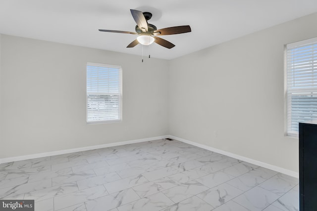 empty room featuring ceiling fan and a healthy amount of sunlight