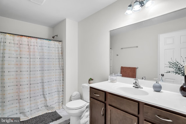 bathroom featuring tile patterned floors, vanity, toilet, and walk in shower