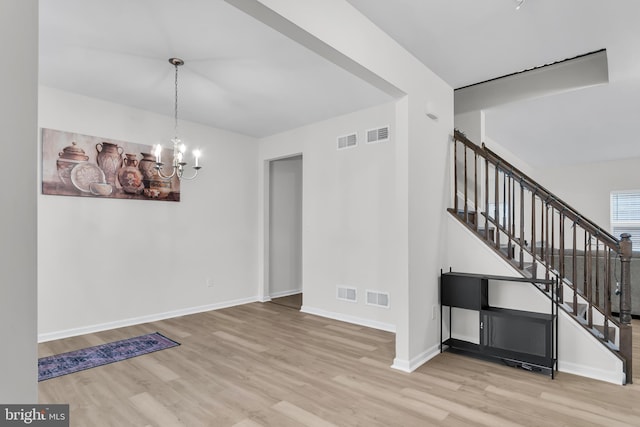 unfurnished dining area featuring a chandelier and light hardwood / wood-style flooring