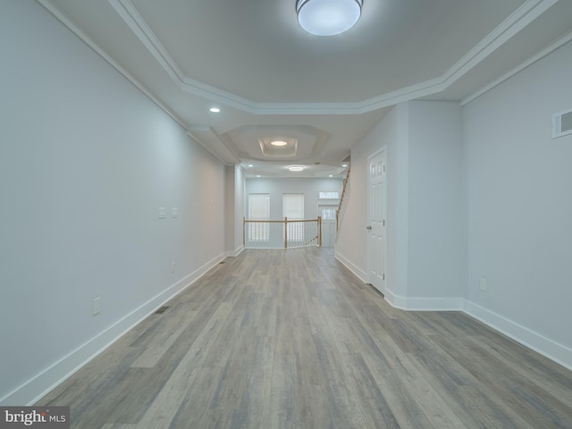 spare room featuring light wood-type flooring and crown molding