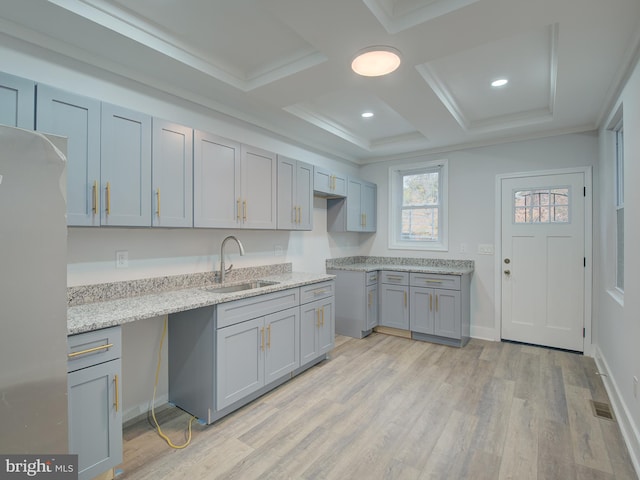 kitchen featuring stainless steel fridge, coffered ceiling, ornamental molding, sink, and light hardwood / wood-style floors