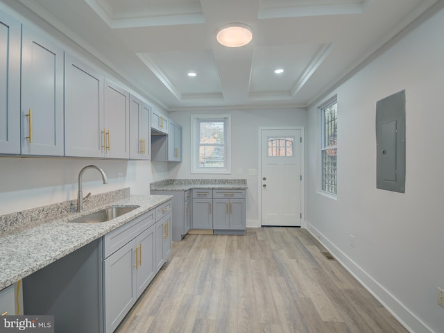 kitchen featuring light stone counters, light hardwood / wood-style floors, crown molding, sink, and electric panel