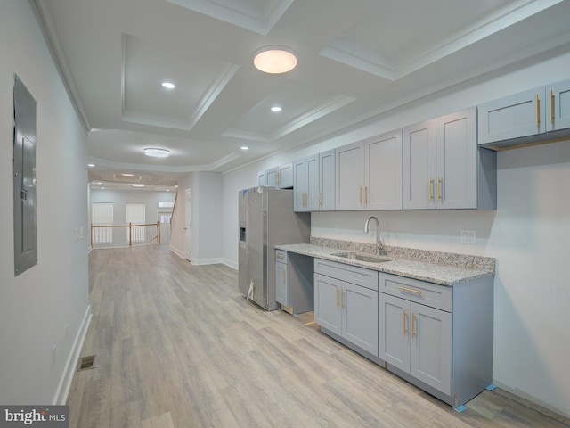 kitchen featuring light stone counters, gray cabinetry, crown molding, sink, and light hardwood / wood-style flooring