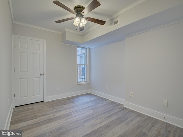 empty room with ceiling fan, light hardwood / wood-style floors, and crown molding