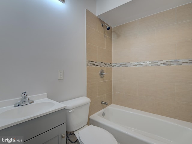 full bathroom with vanity, tiled shower / bath combo, and toilet