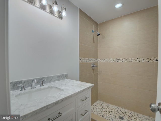 bathroom with vanity and a tile shower