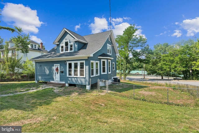 rear view of property with a lawn and cooling unit