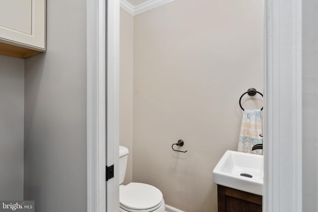 bathroom with vanity, toilet, and ornamental molding