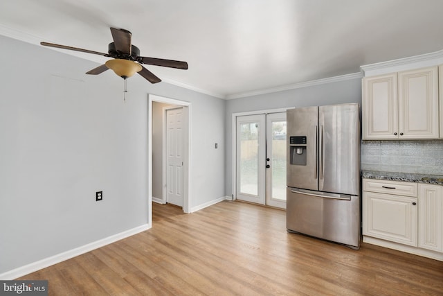 kitchen featuring stainless steel fridge, light wood-type flooring, french doors, ornamental molding, and stone counters