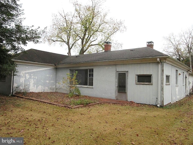 rear view of property with a lawn