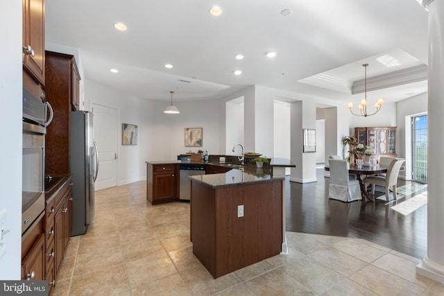 kitchen with pendant lighting, an inviting chandelier, light wood-type flooring, kitchen peninsula, and stainless steel appliances