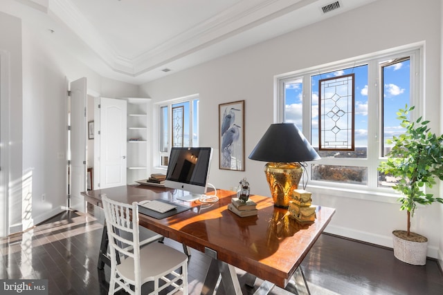 office with a raised ceiling, built in shelves, dark wood-type flooring, and ornamental molding