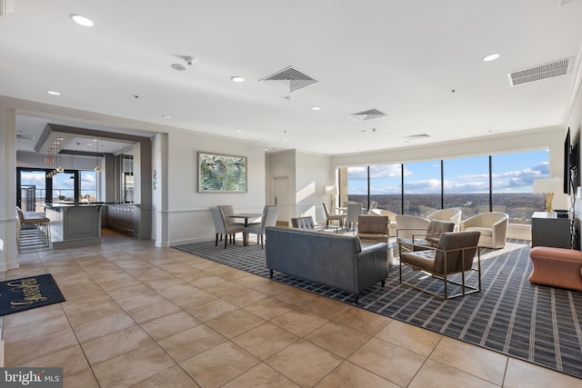 living room featuring light tile patterned floors and ornamental molding