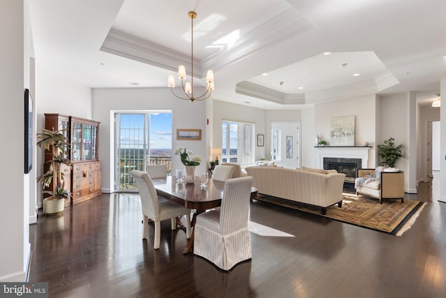 dining space with a tray ceiling, an inviting chandelier, dark wood-type flooring, and crown molding