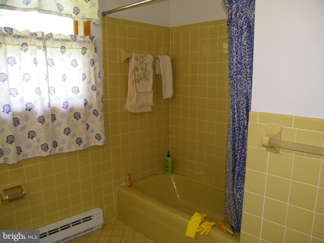 bathroom featuring tile patterned floors, tiled shower / bath combo, tile walls, and a baseboard heating unit