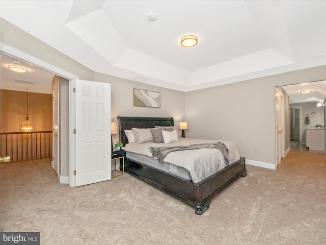 carpeted bedroom with a raised ceiling