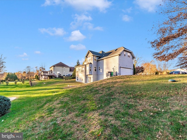 view of side of property featuring a lawn and a garage