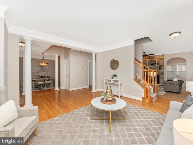 living room with ceiling fan, wood-type flooring, and ornamental molding