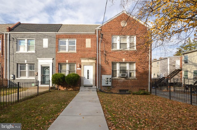 townhome / multi-family property featuring cooling unit and a front lawn