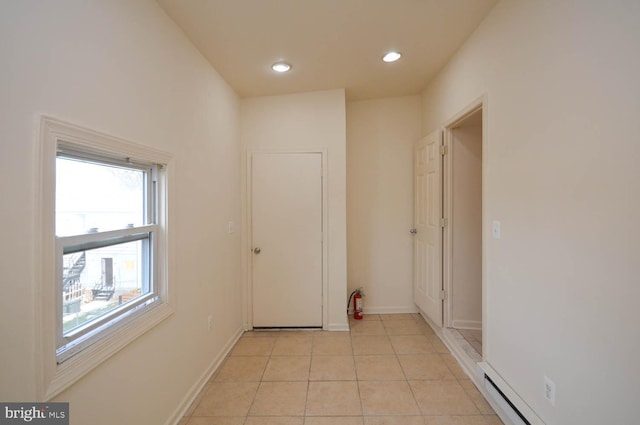 hallway featuring light tile patterned floors and a baseboard radiator