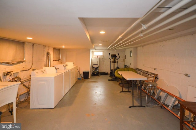 basement featuring washing machine and clothes dryer and fridge