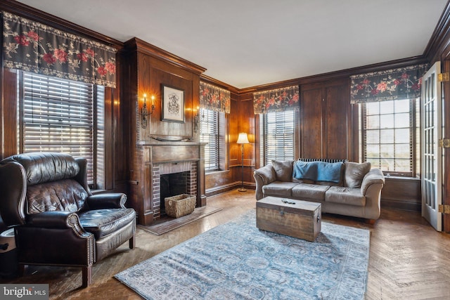 living room featuring a brick fireplace, parquet flooring, a healthy amount of sunlight, and ornamental molding