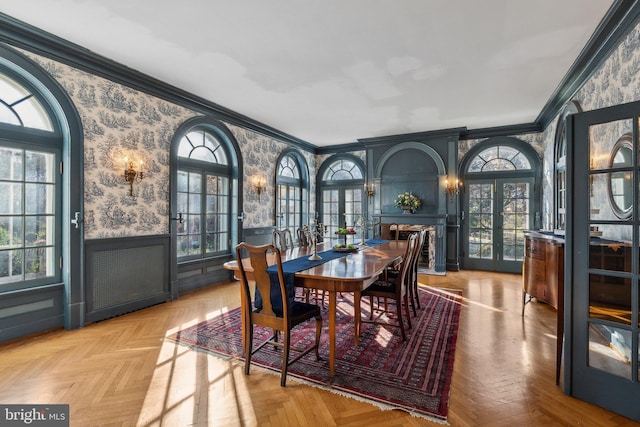 dining space with crown molding and light parquet floors