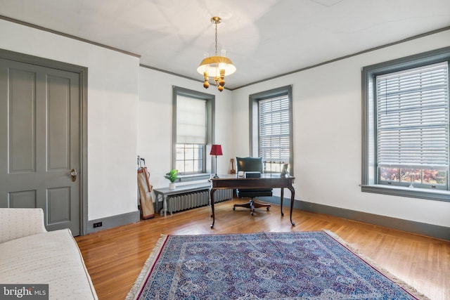 office area with hardwood / wood-style flooring, radiator heating unit, and a chandelier