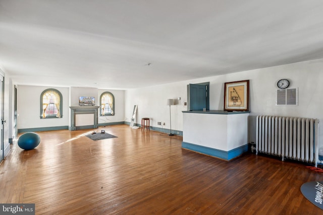 workout room featuring radiator heating unit and hardwood / wood-style floors