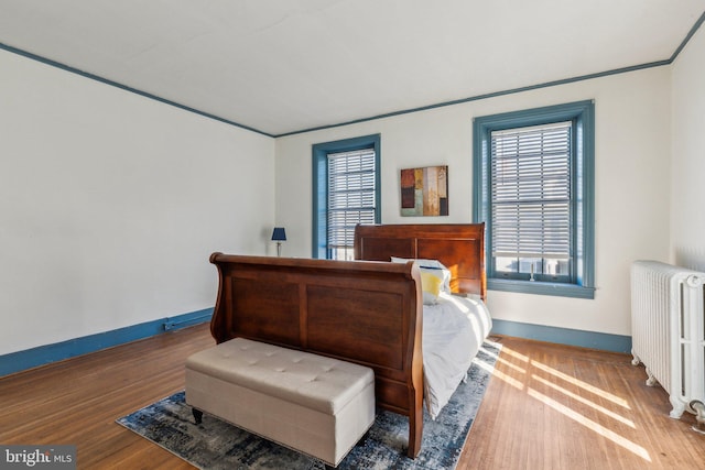 bedroom with hardwood / wood-style flooring and radiator heating unit