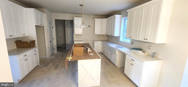 kitchen featuring white cabinets, pendant lighting, light hardwood / wood-style flooring, and a kitchen island