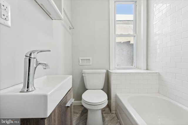 bathroom featuring a tub, sink, and toilet