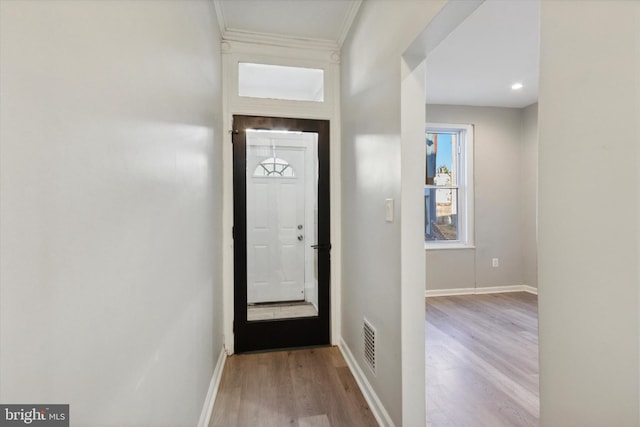 entryway with light hardwood / wood-style floors and ornamental molding