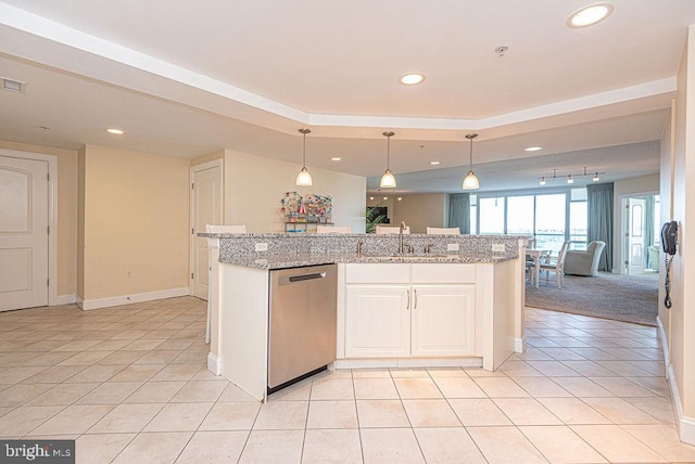 kitchen with dishwasher, decorative light fixtures, light stone counters, and an island with sink