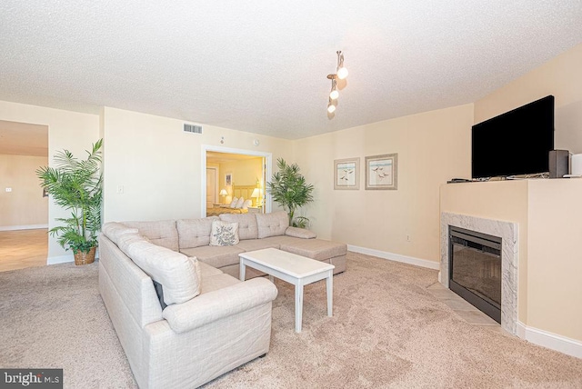 carpeted living room featuring a textured ceiling and a high end fireplace