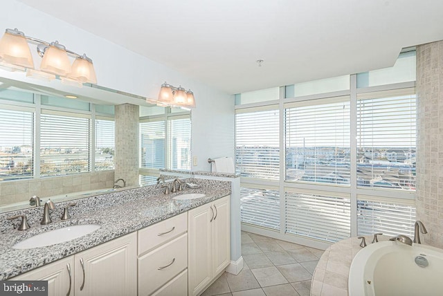 bathroom with tile patterned floors, vanity, and a bath