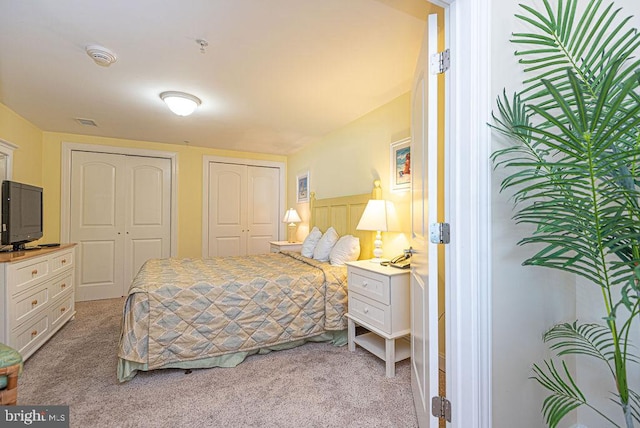 carpeted bedroom featuring two closets