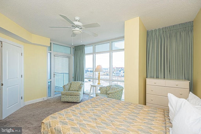 carpeted bedroom featuring ceiling fan and a textured ceiling