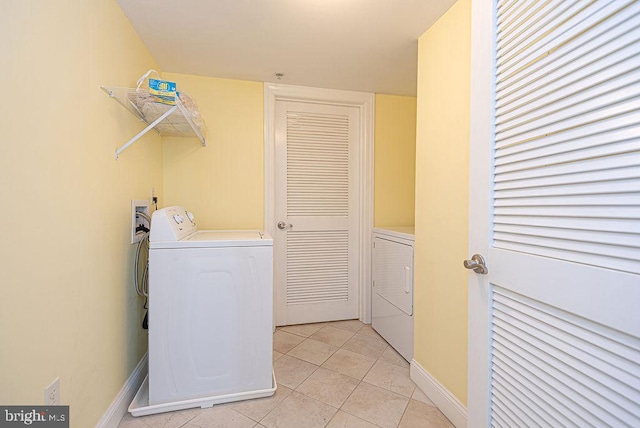 laundry room featuring washer and dryer and light tile patterned floors