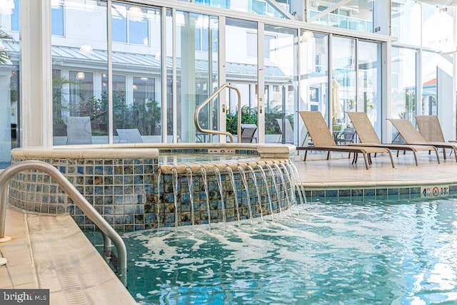 view of pool with a patio area, pool water feature, and a hot tub