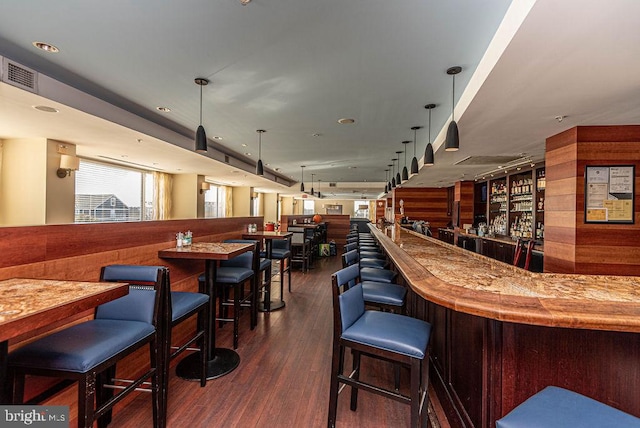 bar with pendant lighting and dark hardwood / wood-style floors