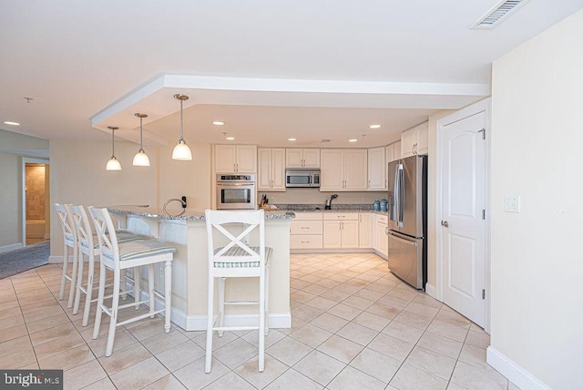 kitchen featuring a breakfast bar, hanging light fixtures, light tile patterned floors, light stone countertops, and stainless steel appliances