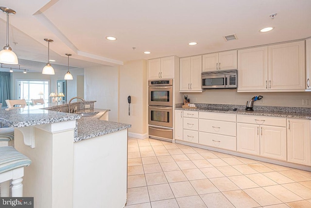 kitchen with decorative light fixtures, sink, white cabinetry, and stainless steel appliances