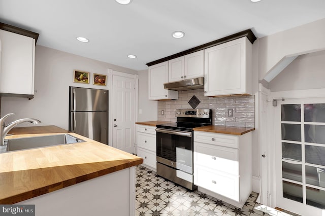 kitchen with stainless steel appliances, white cabinetry, sink, and wooden counters