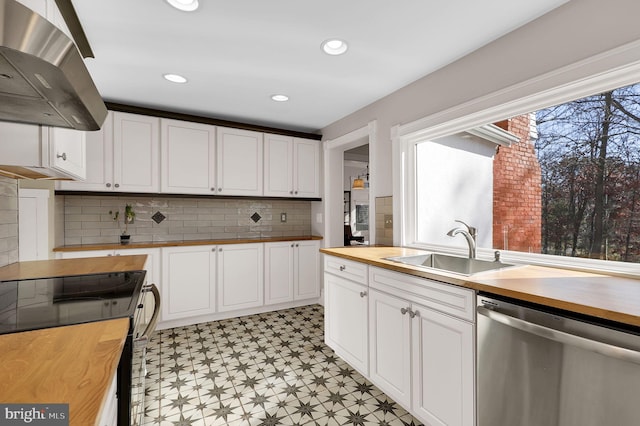 kitchen featuring dishwasher, white cabinets, butcher block counters, and exhaust hood