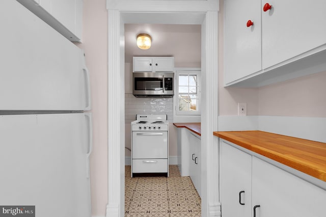 kitchen with decorative backsplash, white appliances, and white cabinetry